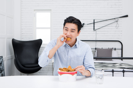 Asian man - eating fried chickenの写真素材