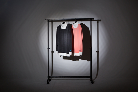 Apparel products photoshooting display - Shirts hanging on a hanger in black/gray backgroundの写真素材