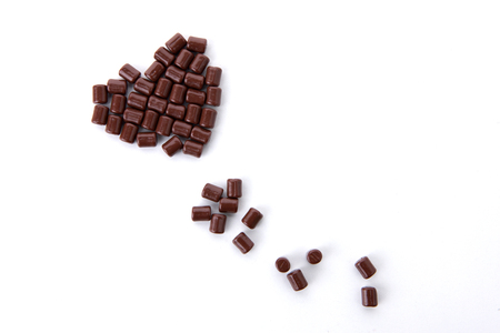 Sweet desserts - Heart made with small chocolates in white backgroundの写真素材