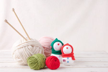 Knitting wool balls with needles and snowman dolls shot in studioの写真素材