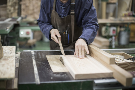 Isolated shot of hands of woodcraft experts measuring wood pieces with tools