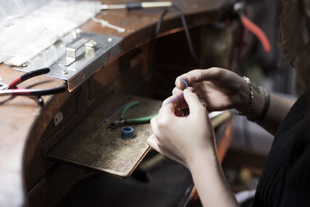 Isolated shot of hands of handmade craft jewerly experts making a piece with/using tools/machinesの写真素材