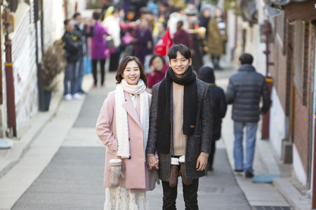 Asian couple dating in street - posing as looking into cameraの写真素材