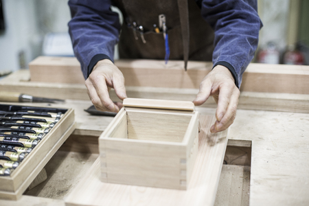 Isolated shot of hands of woodcraft experts combining completed pieces togetherの写真素材