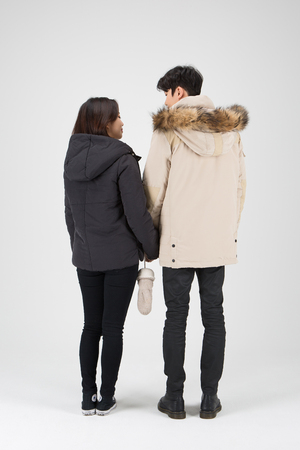 Asian couple isolated in white studio - back shot of holding hands togetherのeditorial素材