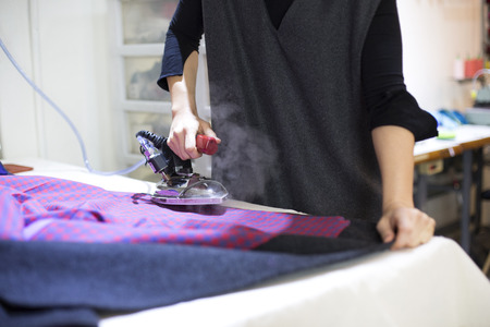 Isolated shot of a tailor's hands ironing jacket/product/fabricの写真素材