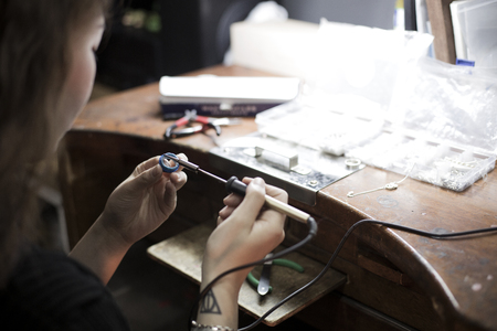 Isolated shot of hands of handmade craft jewerly experts making a piece with/using tools/machines