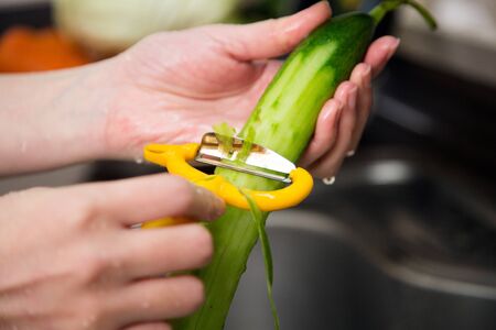 Isolated shot of cook's hands washing fresh ingredients - Green cucumbersの写真素材