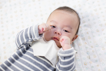 Baby studio photoshoot - Isolated shot of Asian baby/infant lying on backの写真素材