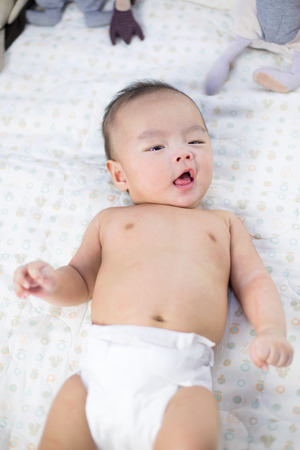 Baby studio photoshooting - Asian baby/infant lying on back as wearing diapersの写真素材