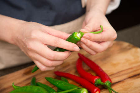 Isolated shot of cook's hands prepparing fresh ingredients - Gree peppers/Red peppersの写真素材