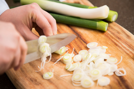 Isolated shot of cook's hands prepparing fresh ingredients - Green onions/Spring onionsの写真素材