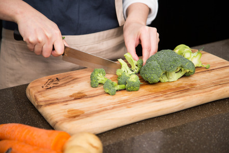 Isolated shot of cook's hands prepparing fresh ingredients - Broccoliの写真素材