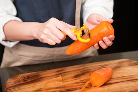 Isolated shot of cook's hands prepparing fresh ingredients - Carrotsの写真素材