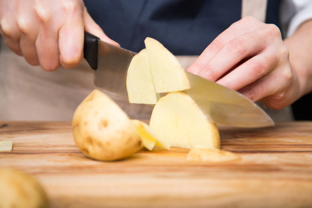 Isolated shot of cook's hands prepparing fresh ingredients - Potatoesの写真素材
