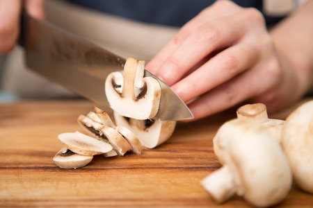 Isolated shot of cook's hands prepparing fresh ingredients - Mushroomsの写真素材