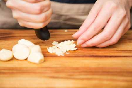 Isolated shot of cook's hands prepparing fresh ingredients - Garlicsの写真素材