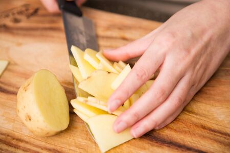Isolated shot of cook's hands prepparing fresh ingredients - Potatoesの写真素材