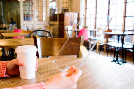 Isolated shot of hands holding/grabbing and operating/using transparent tablet PC with both handsの写真素材