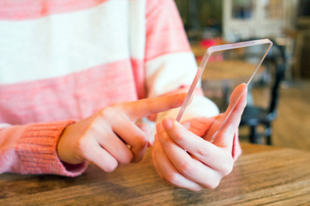 Isolated shot of hands holding/grabbing and operating/using transparent smart phoneの写真素材