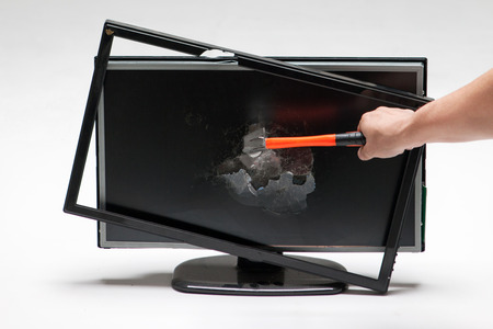Damaged/Smashed/Broken computer monitor/TV/desktop with a hammer in white backgroundの写真素材