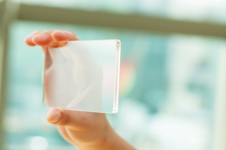 Isolated shot of hands holding/grabbing transparent smart phoneの写真素材