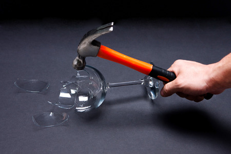 Damaged/Smashed/Broken wine glass and a hammer in black backgroundの写真素材