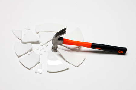 Damaged/Smashed/Broken plate and a hammer in white backgroundの写真素材
