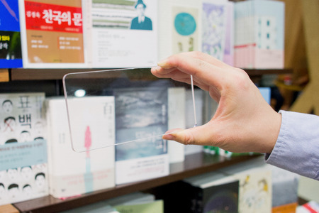 Isolated shot of hands holding/grabbing transparent smart phoneの写真素材