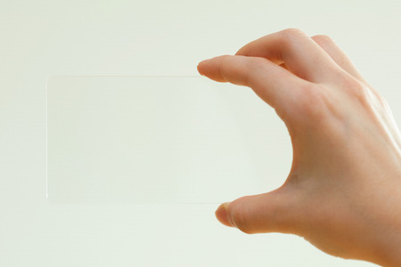 Isolated shot of hands holding/grabbing transparent smart phoneの写真素材