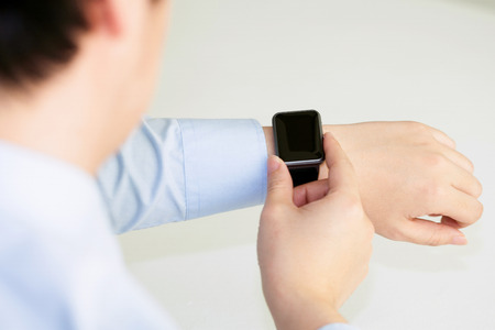 Isolated shot of hands and wrists operating/using smart watch and credit card