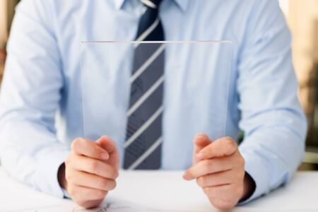 Isolated shot of hands holding/grabbing and operating/using transparent tablet PC with both handsの写真素材