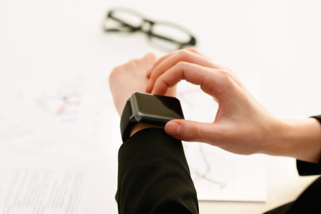 Isolated shot of hands and wrists operating/using smart watch