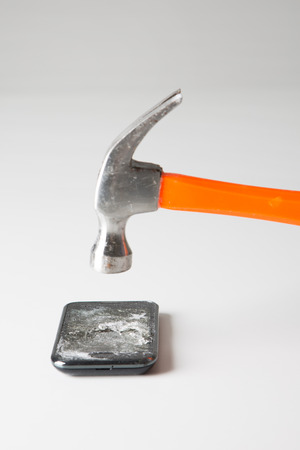 Damaged/Smashed/Broken smart device/phone with a hammer in white backgroundの写真素材