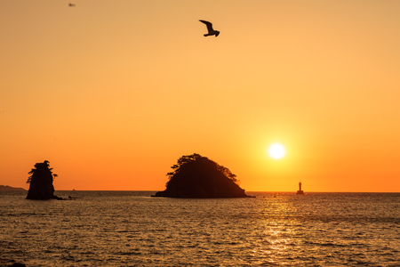 Ocean coast at sunset - scenery of rock island with the sunの写真素材