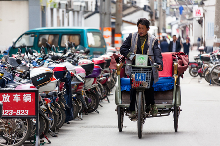 Suzhou, China - A man driving rickshaws in the streetのeditorial素材