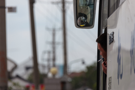 Suzhou, China - Bus driver smoking as peaking out of the windowのeditorial素材