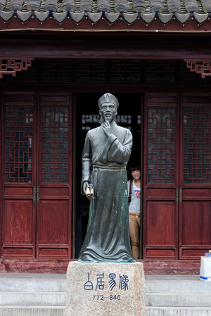 Suzhou, China - Asian female posing behind the statue of saint for photosotのeditorial素材