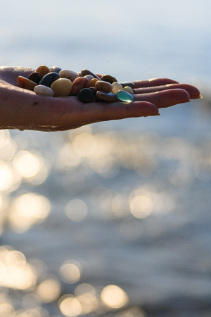 Life in island - a palm full of colorful gravelsの写真素材