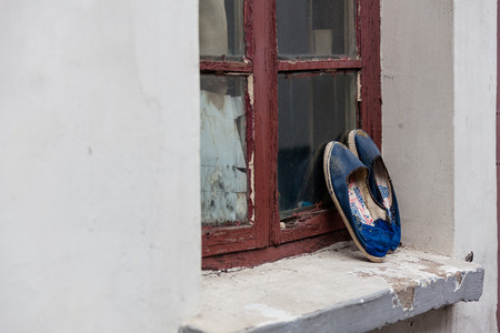 Suzhou, China - A pair of shoes standing against the windowsの写真素材