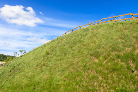 Scenery of grass dune with wooden fences under the blue skyの写真素材