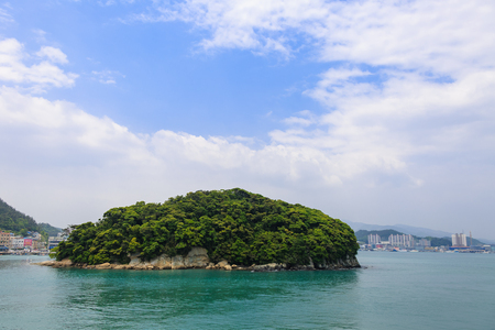 Slow city island-Scenery of rock island covered with treesの写真素材