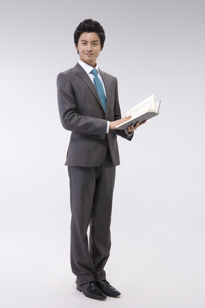 Asian man posing in a studio - with booksの写真素材