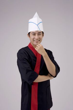 Male chef/cook in uniform posing in a studioの写真素材