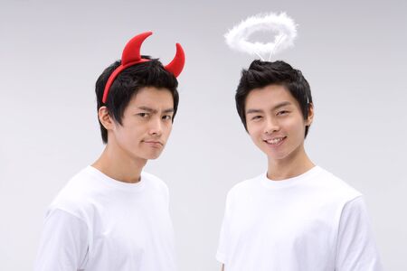 Young Asian men devil/evil versus angelの写真素材