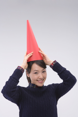 Asian woman posing in a studio with a cheering hornの写真素材