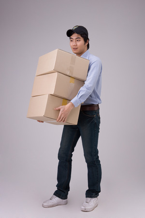 Delivery man carrying boxes of shipmentsの写真素材