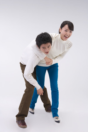 A couple of young Asian man and woman posing in a studioの写真素材