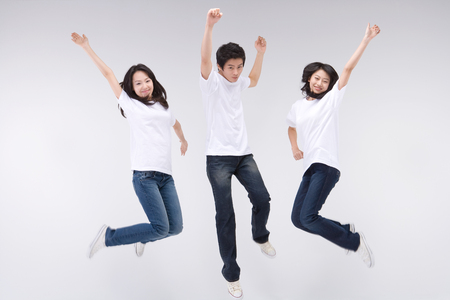 Two young Asian women and a man posing in a studioの写真素材