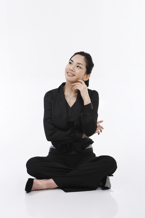 Female Asian in suit posing in a studioの写真素材